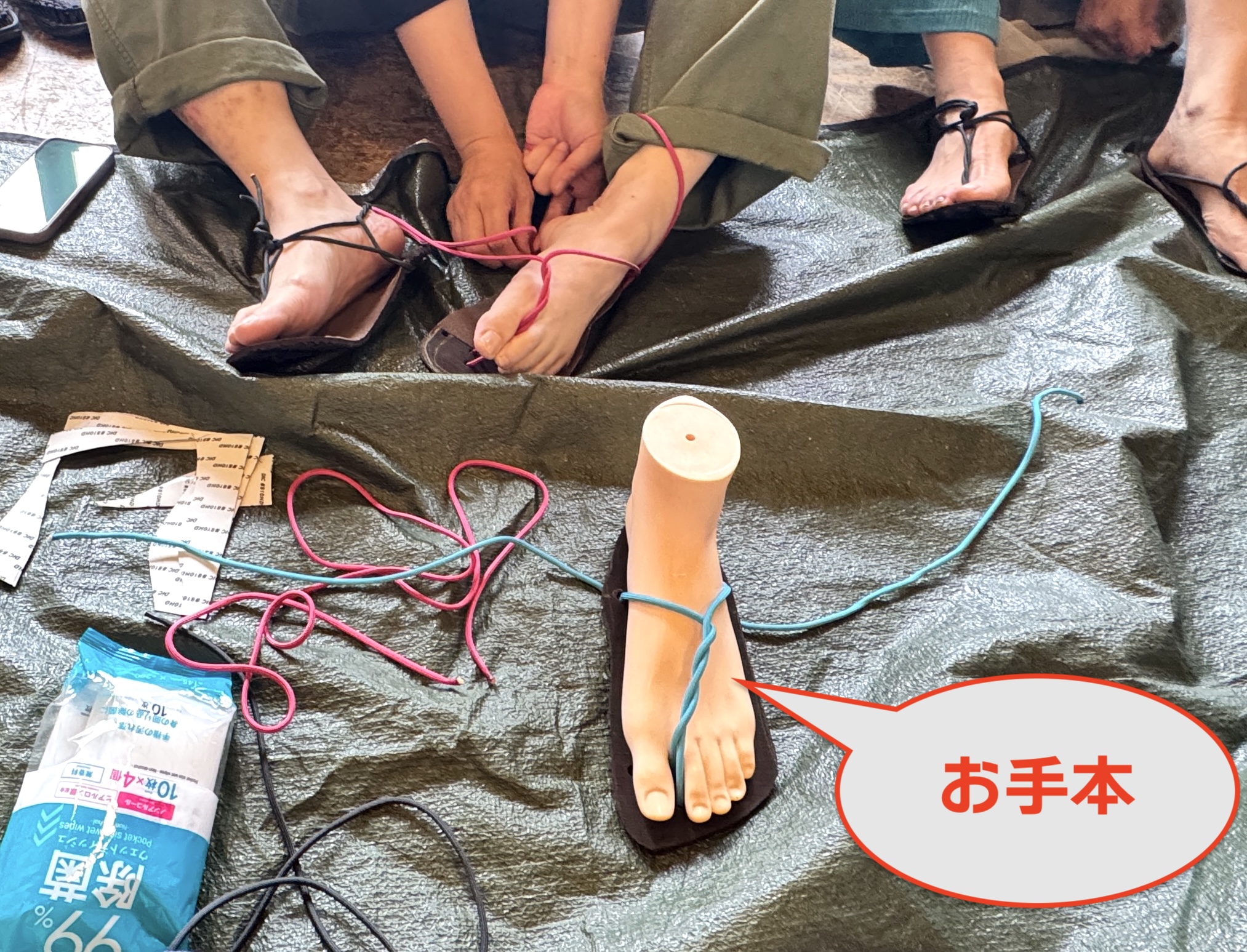 足マネキンのお手本で実際にワラーチを作り、参加者のみなさんにそれを真似していただいて、一段回ずつゆっくり作っていく方式で、ワラーチづくりを指導しています。