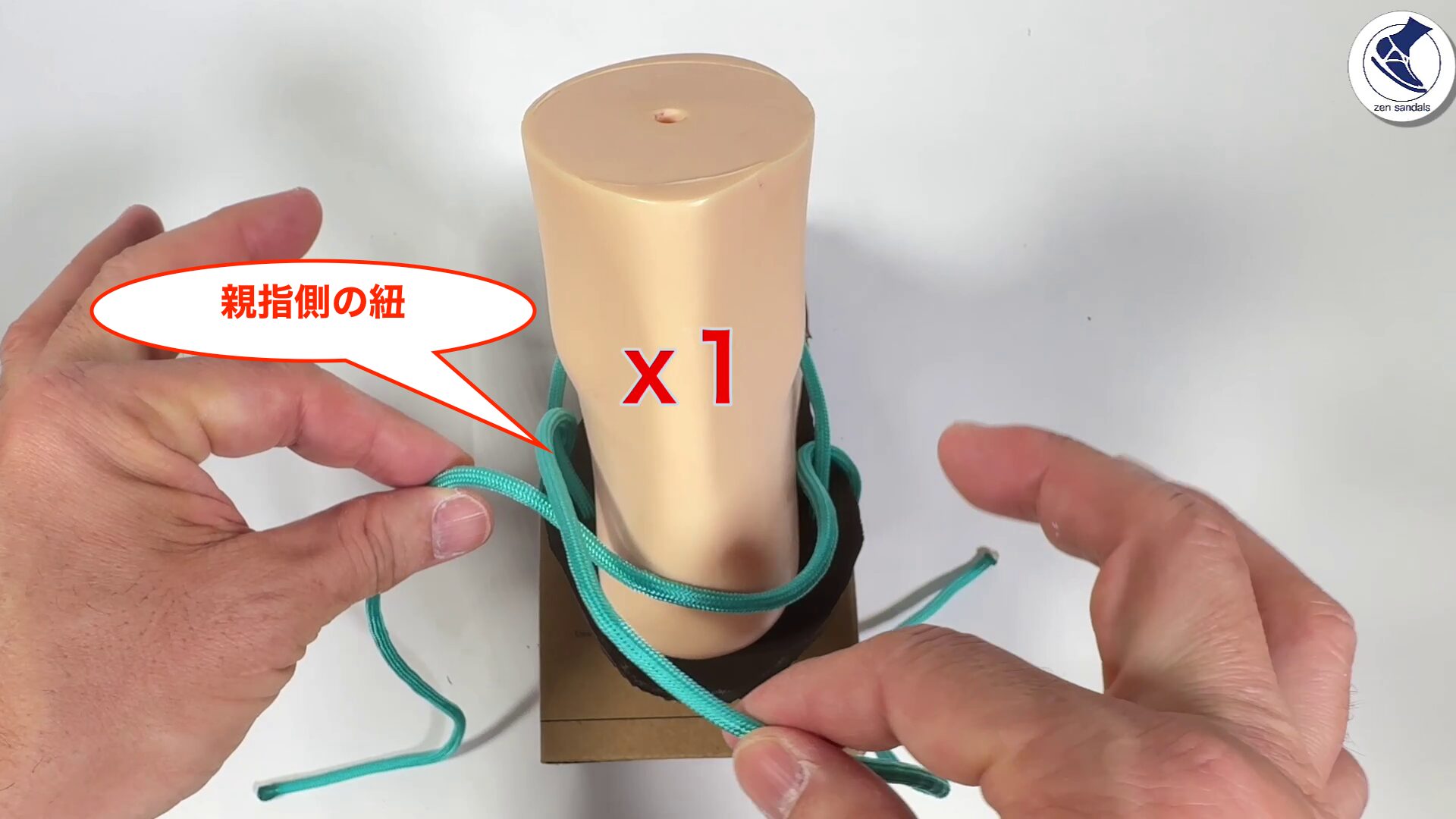 親指側の紐を小指側の紐の上に被せます。