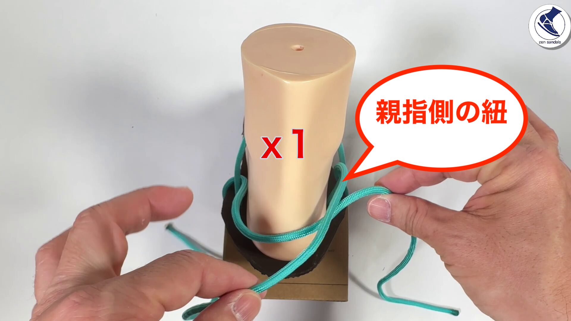 親指側の紐を小指側の紐の上に被せます。